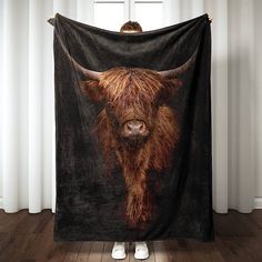 a person standing in front of a curtain with a black and brown cow head on it