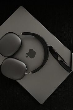 an apple computer mouse and headphones on top of a tabletop with a pair of glasses next to it