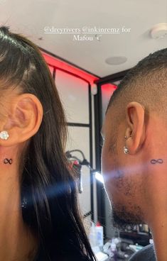 a man and woman with ear piercings looking at each other