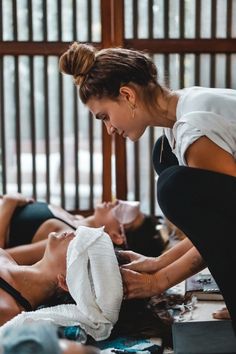 two women are getting their hair done at the same time as another woman is lying on the floor