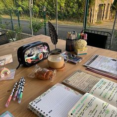 a wooden table topped with lots of writing supplies