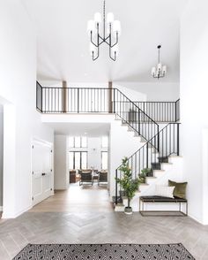 a large open floor plan with stairs and chandelier