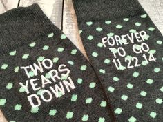 two pairs of socks that say, two years to go down with green polka dots on them