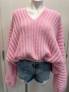 a mannequin wearing a pink sweater and denim shorts