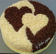 a cake with white and brown frosting in the shape of a heart