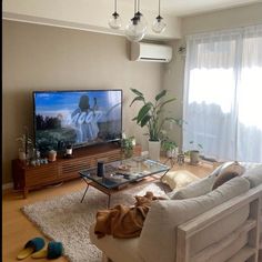 a living room filled with furniture and a flat screen tv on top of a wooden table