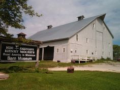 a large white barn with a sign in front of it that says barn museum on the side