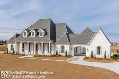 a large white house with lots of windows on the front and side of it's roof