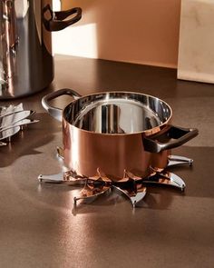 a pot and pan sitting on top of a counter next to a coffee pot with tongs