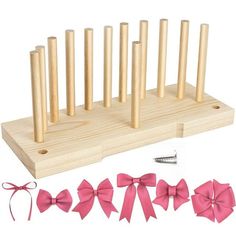 a set of wooden pegs with pink bows on them and pins in the middle