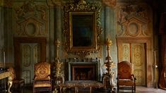 an ornately decorated room with two chairs and a fireplace