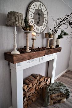 a mantle with candles, pine cones and other items on it next to a clock