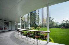 an outdoor area with tables and chairs on the grass, overlooking a large open field