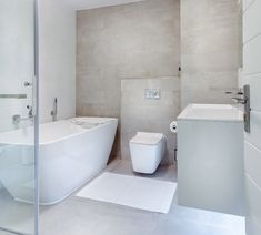 a bathroom with a toilet, sink and bathtub in it's center wall