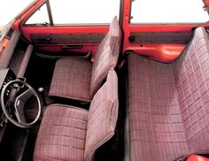 the interior of an old red car with leather seats and steering wheel, in front of a white background