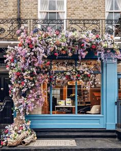 a blue building with flowers on the outside