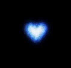 a heart shaped object in the dark with blue light coming from it's center