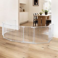 a white baby gate in the middle of a living room next to a dining table