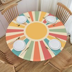 the table is set with white plates and silverware on it, along with two wooden chairs