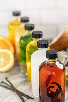 several bottles filled with liquid sitting on top of a table next to sliced lemons