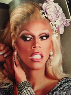 a woman with flowers in her hair is posing for a magazine cover story about drag queen marilyn monroe