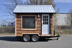 a tiny house on wheels parked in a parking lot