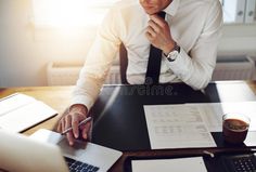 a man sitting at a desk with his laptop and papers