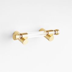 an image of two gold colored handles on a white wall with no one in it