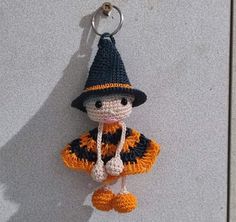 a crocheted keychain with a stuffed animal wearing a hat and scarf