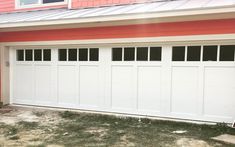 a red and white house with two garage doors