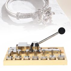 a diamond ring sits on top of a wooden stand with metal knobs in front of it