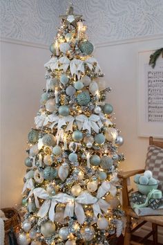 a white christmas tree with blue and silver ornaments