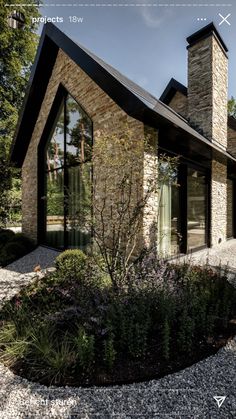 a stone house with black roof and windows