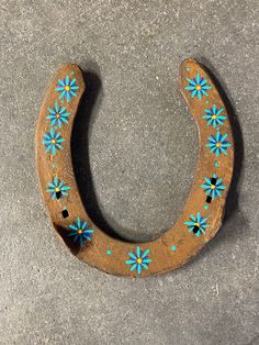 a wooden horseshoe with blue flowers painted on it