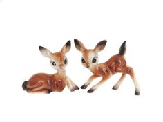 two small deer figurines sitting next to each other