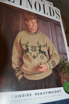 a magazine with an image of a man in a sweater holding a plant and smiling