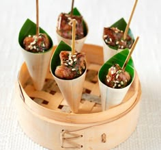 small food items are placed on sticks in a bamboo container