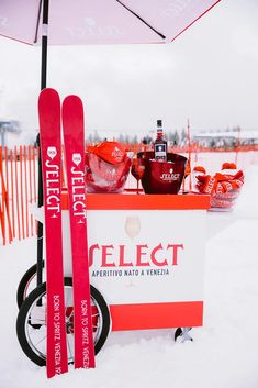 a red and white cart with skis on it in the snow