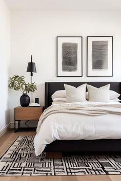 a bed with white sheets and pillows in a bedroom next to two framed pictures on the wall