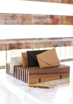 three envelopes sitting on top of a wooden box