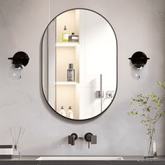 a bathroom sink sitting under a round mirror