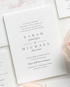 the wedding stationery is laid out on top of each other, with pink flowers