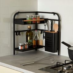 a kitchen shelf with spices and cooking utensils on the counter next to a stove