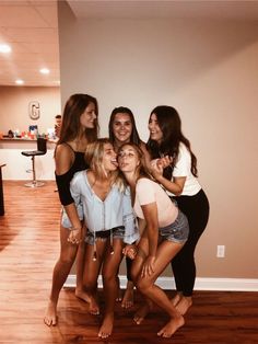 a group of young women standing next to each other on top of a hard wood floor