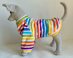 a stuffed dog wearing a colorful striped shirt