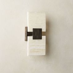 a marble and metal wall mounted toilet paper dispenser on a white wall