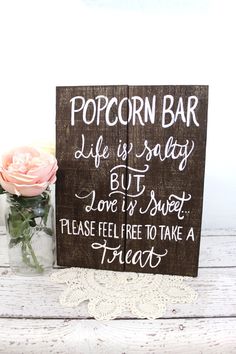 a sign that says popcorn bar life is salty but love is sweet please feel free to take a treat