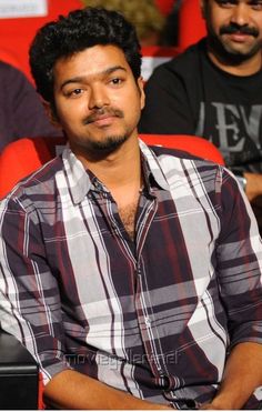 a man sitting in a red chair with his arms crossed