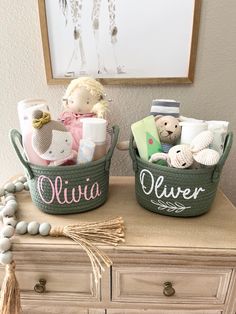 two baskets filled with baby items sitting on top of a dresser