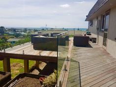 a wooden deck overlooking the ocean on a sunny day